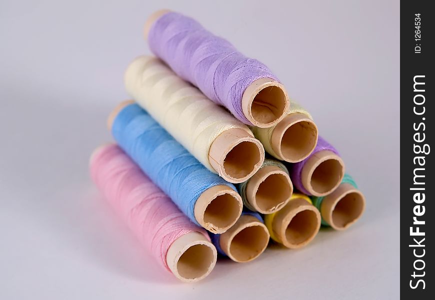 Different color sewing thread on light background