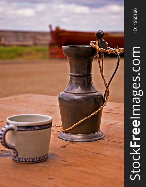 A cup and gauntlet sitting on a table in the streets of Louisbourg. A cup and gauntlet sitting on a table in the streets of Louisbourg