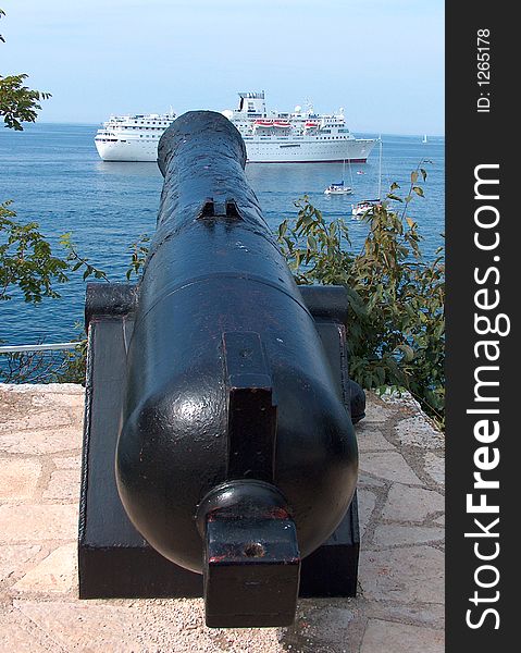 Cannon aiming at cruise ship. Cannon aiming at cruise ship