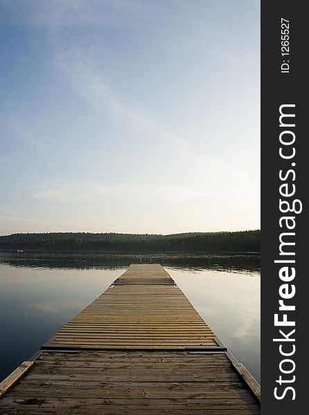 Wooden jetty leading out into a still lake