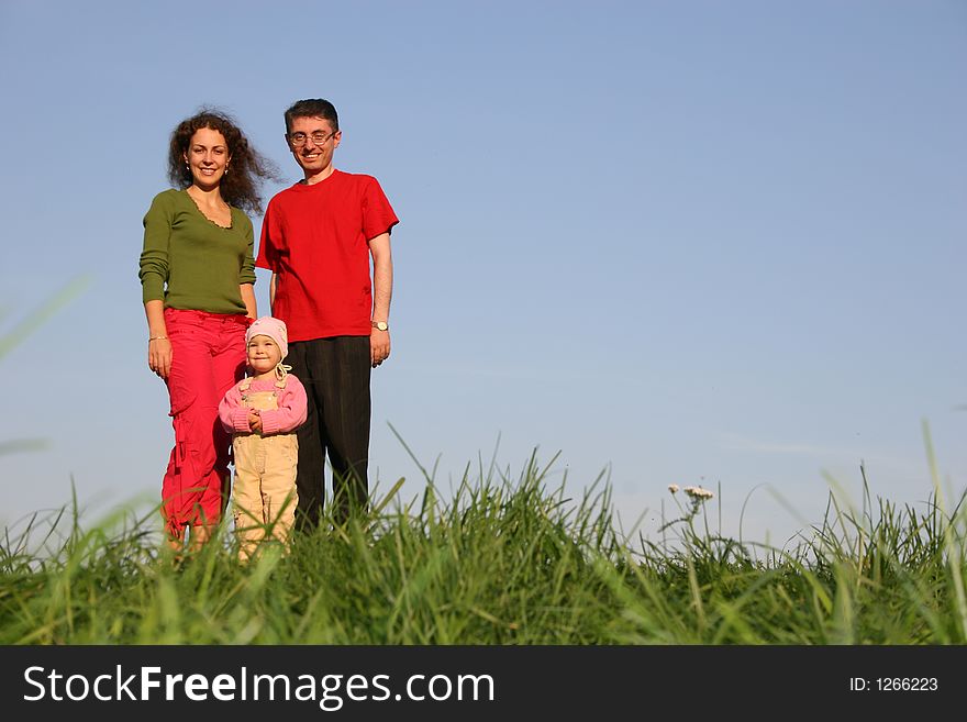 Family with baby stand on grass