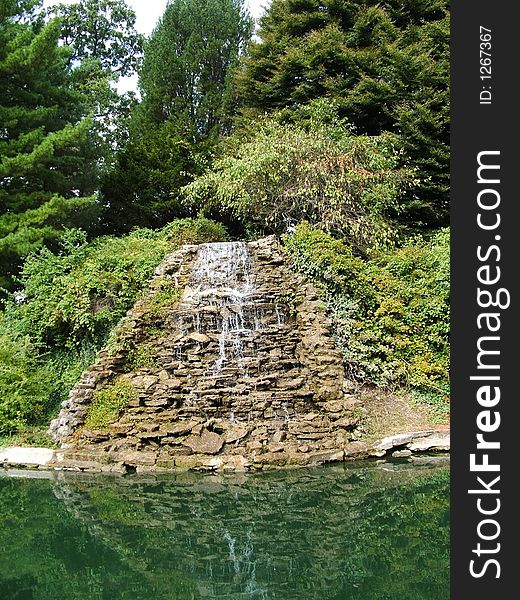 Water flowing through a cascade of rocks mirrored in the water below. Water flowing through a cascade of rocks mirrored in the water below