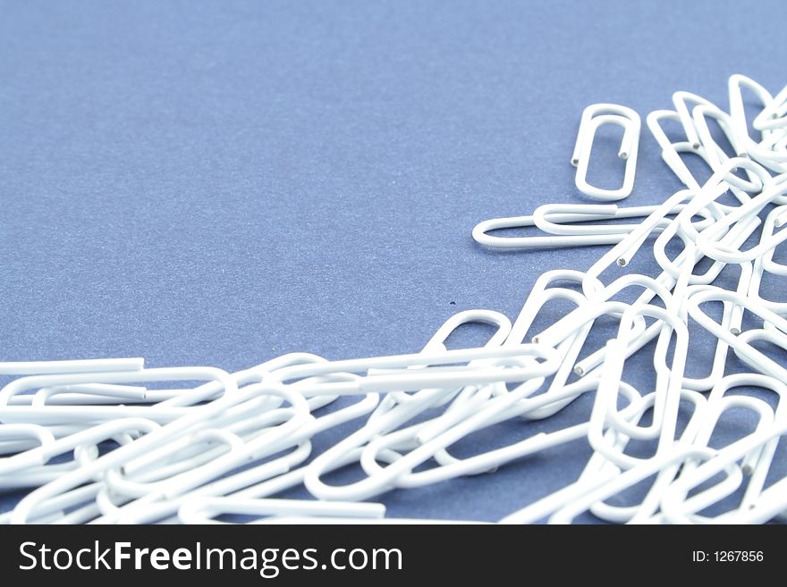 White paper clips on a blue background