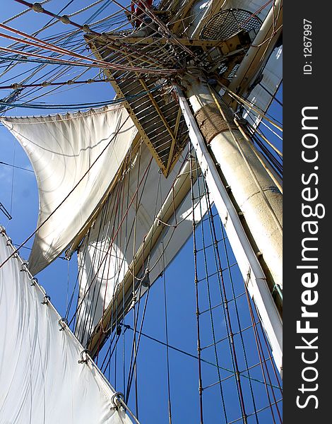 Photo of mast, staysails and ropes of tall ship against blue sky. Photo of mast, staysails and ropes of tall ship against blue sky