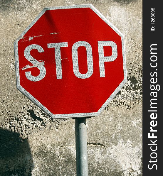Street sign stop behind old wall surface. Street sign stop behind old wall surface