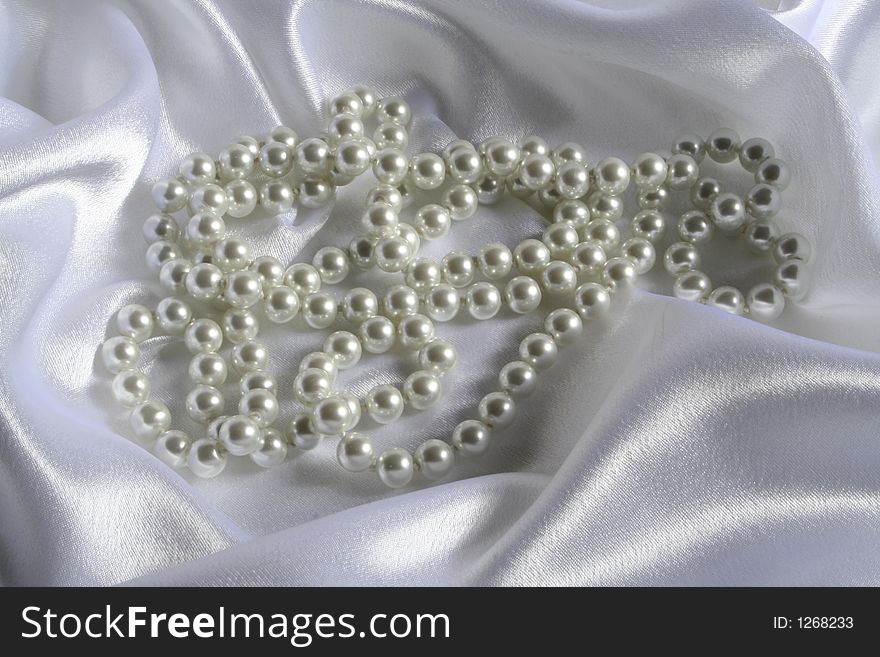 Pearls a necklace on a silk fabric