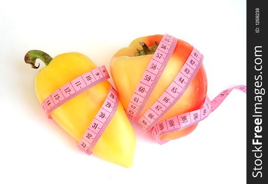 Two peppers with pink tape measure against white background