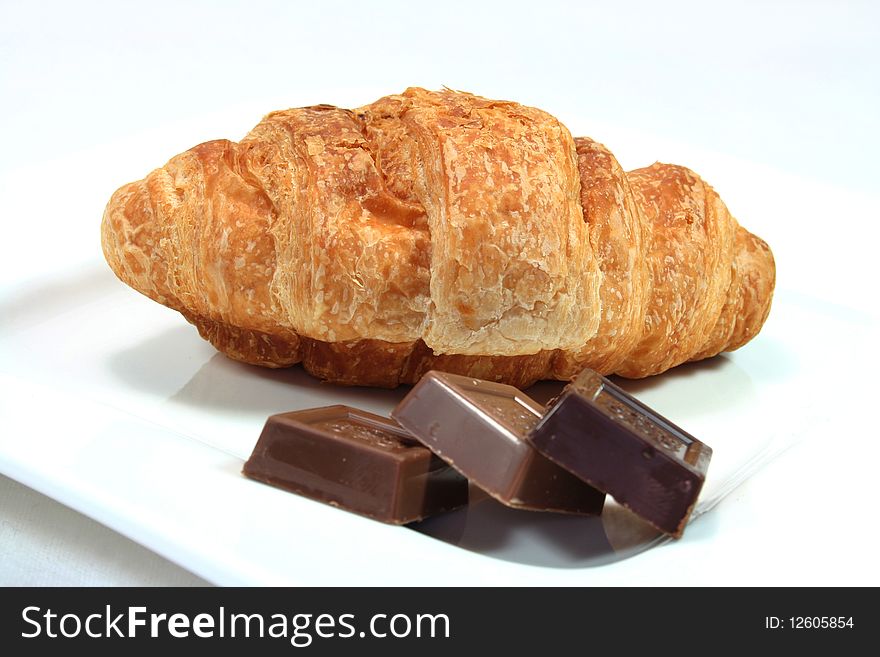 Croissant with chocolate on a white plate