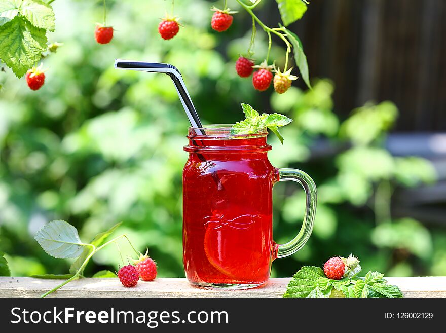 Compote In A Glass Cup Fresh Raspberry On A Rustic Wooden Table Outdoors. Authentic Lifestyle Image. Seasonal Harvest Crop Local P