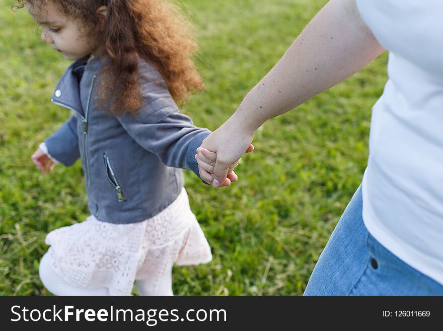 Mather and baby girl holding hand in hand. Friendship in family