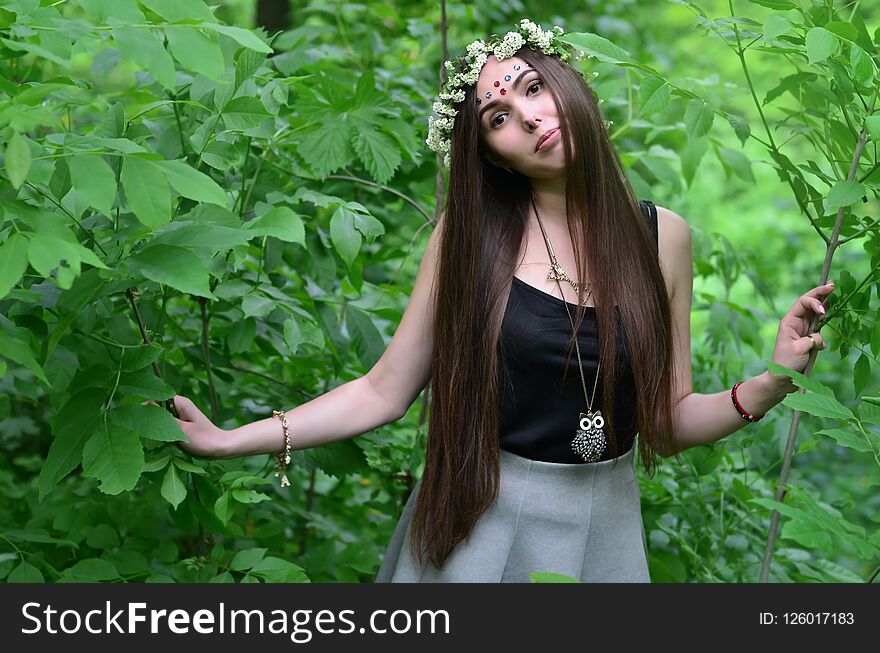 A forest picture of a beautiful young brunette of European appearance with dark brown eyes and large lips