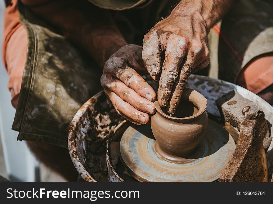 Master hands makes a pot of clay. Master class is held in nature, close-up