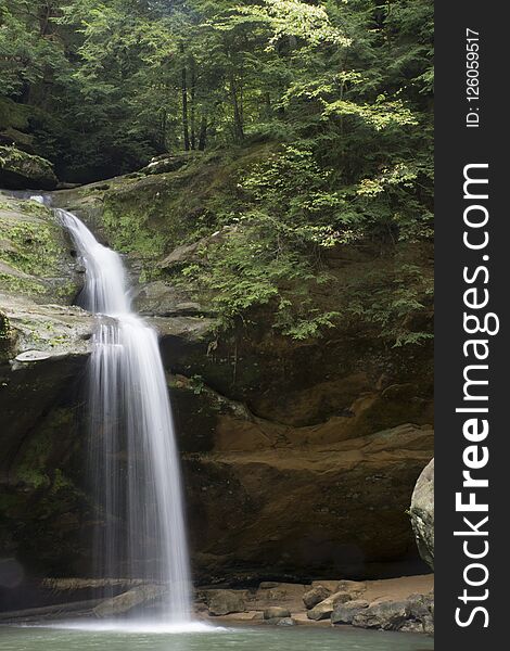 Lower falls in the Hocking Hills State Forest in the old man`s cave area near Logan, Ohio. The waterfall makes a dramatic view plummeting from a rock Clif into a deep pool of water at the bottom of the gorge. Lower falls in the Hocking Hills State Forest in the old man`s cave area near Logan, Ohio. The waterfall makes a dramatic view plummeting from a rock Clif into a deep pool of water at the bottom of the gorge.