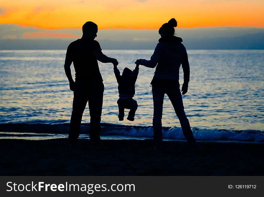 Happy family with baby on the beach at sunset. Happy family with baby on the beach at sunset