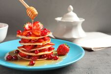 Pouring Honey Onto Tasty Pancakes With Berries Royalty Free Stock Image