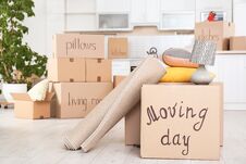 Moving Boxes And Household Stuff In Kitchen. Stock Photos