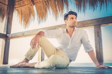 Beautiful Young Relaxed Man In A Small Wooden Deck. Strong Summer Warm Light Royalty Free Stock Images