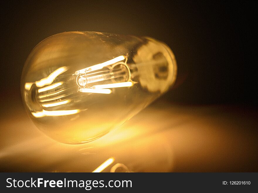 Close-up photo of light bulb on dark background. High quality.