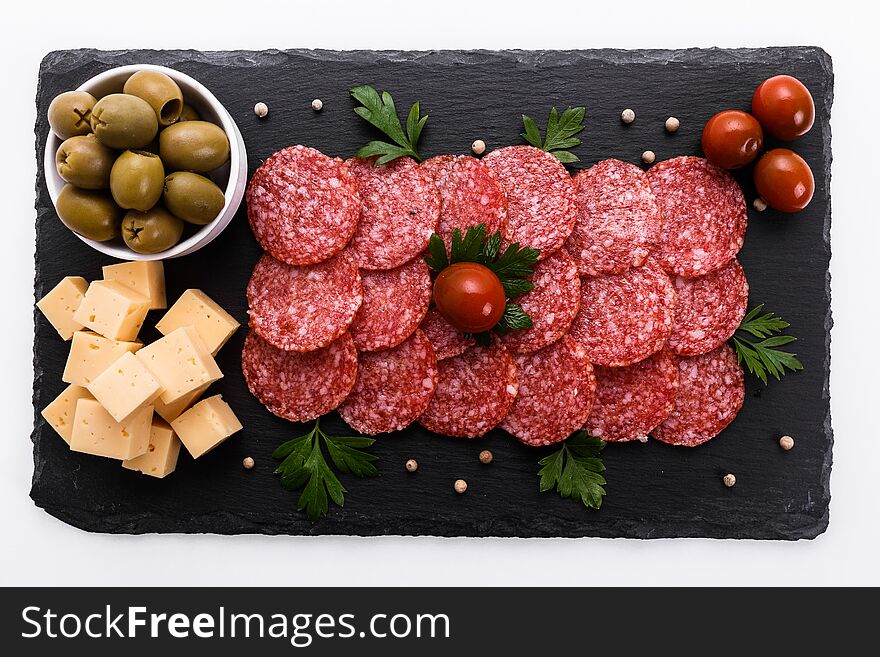 Delicious sliced salami on a stone plate. Delicious sliced salami on a stone plate.