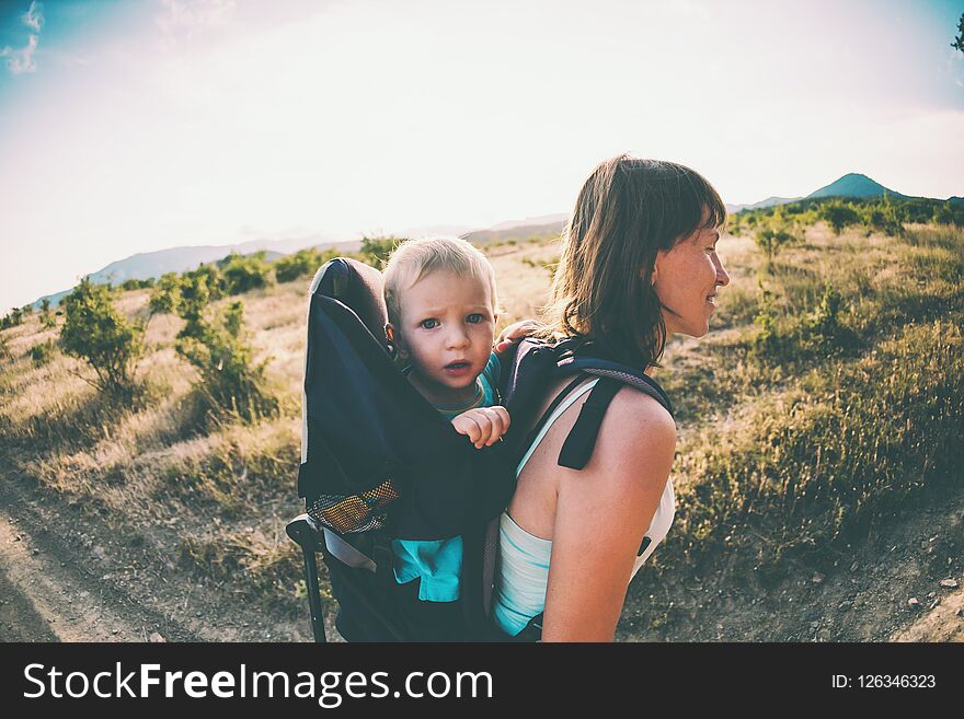 A woman is carrying a backpack with her baby.
