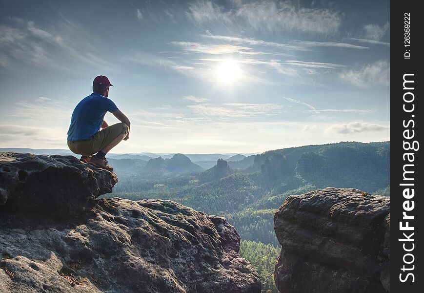 Hiker watching to Sun at horizon. Beautiful moment the miracle of nature. Colorful mist in valley. Man hike.