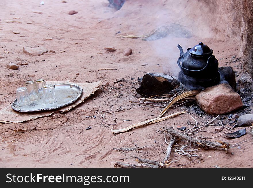 Petra, the fabled rose red city, half as old as time, is a well known ancient Nabataean city in the south of Jordan. Due to its breathtaking grandeur and fabulous ruins, Petra was recognized as a World Heritage Site by UNESCO in 1985. In this picture a kattle of jordan bedouin tea boiling on a camp fire of juniper wood. Teas are often offered to tourists that stop at the many stall to buy goods and souvenires. Petra, the fabled rose red city, half as old as time, is a well known ancient Nabataean city in the south of Jordan. Due to its breathtaking grandeur and fabulous ruins, Petra was recognized as a World Heritage Site by UNESCO in 1985. In this picture a kattle of jordan bedouin tea boiling on a camp fire of juniper wood. Teas are often offered to tourists that stop at the many stall to buy goods and souvenires.