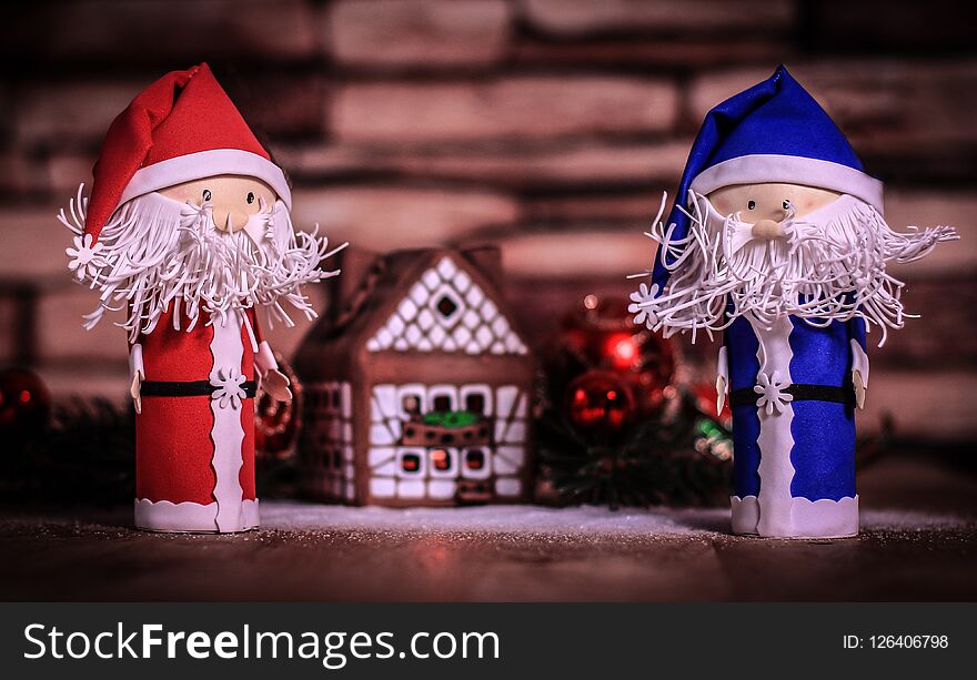 Two Funny Santa Claus On The Background Of A Gingerbread House.