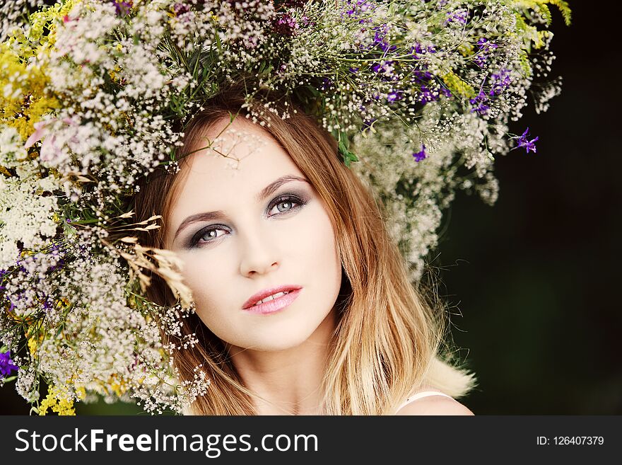 A girl in a wreath of field flowers