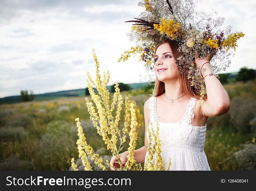 A girl in a wreath of field flowers