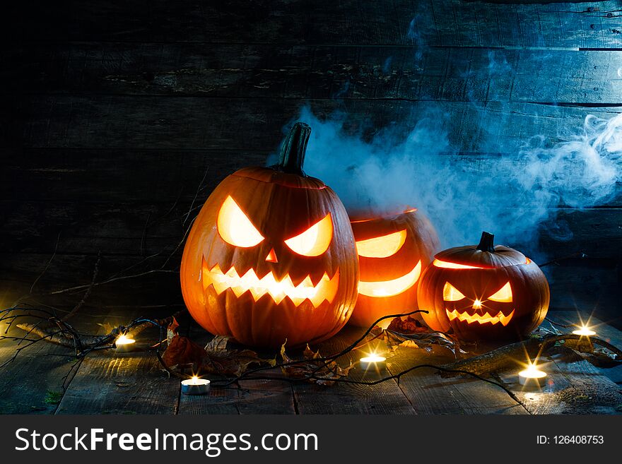 Halloween pumpkin head jack o lantern and candles on wooden background. Halloween pumpkin head jack o lantern and candles on wooden background