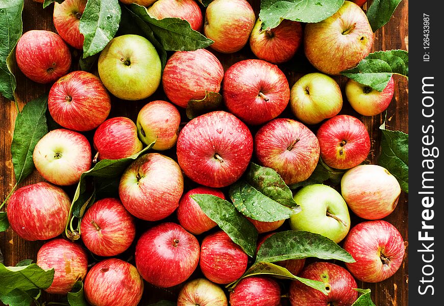 Ripe red apples with leaves on wooden background. Shallow dof. Ripe red apples with leaves on wooden background. Shallow dof.