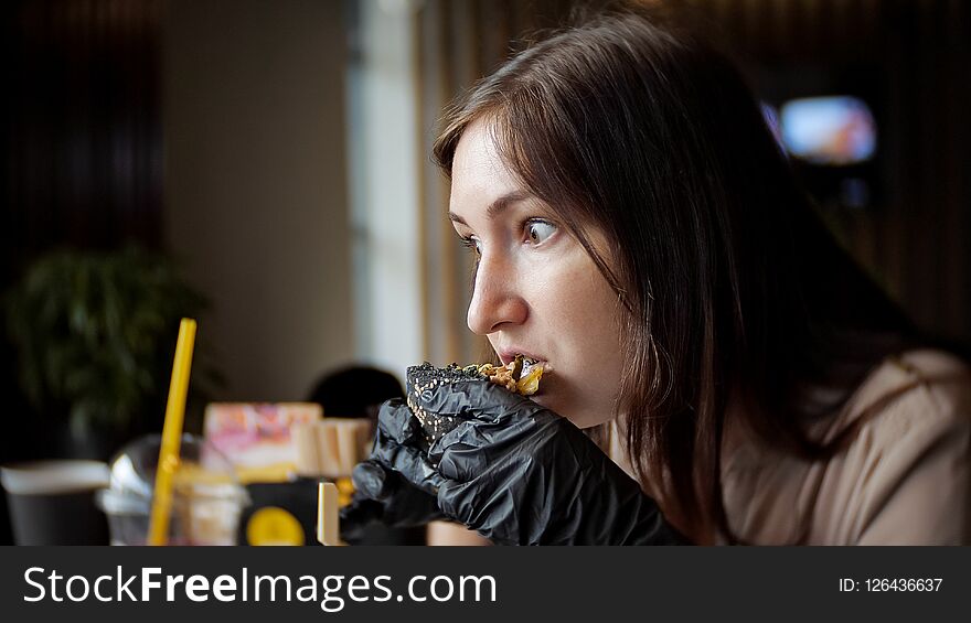 Pretty Woman Eating Fast Food Burger At Cafe