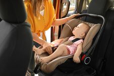 Mother Fastening Baby To Child Safety Seat Inside Royalty Free Stock Images