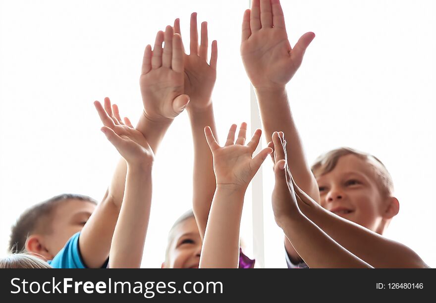 Little children raising hands together