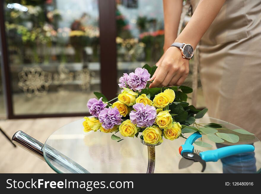 Female florist making beautiful bouquet in flower shop