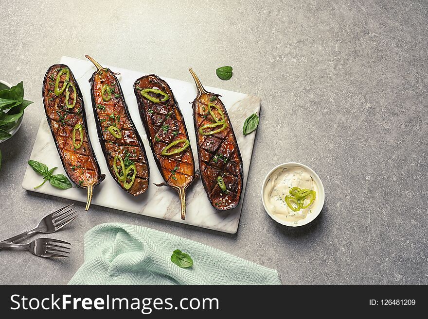 Board with fried eggplant slices on table, top view