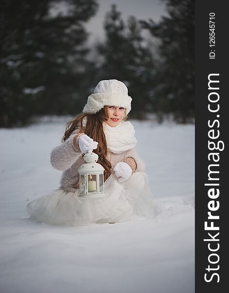 Little happy beautiful girl in winter forest