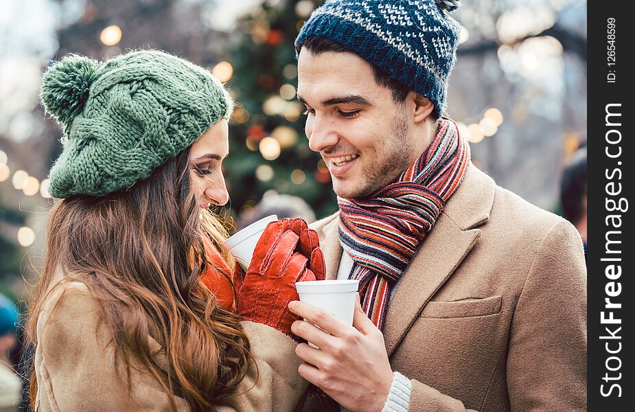 Woman And Man Drinking Mulled Wine On Christmas Market