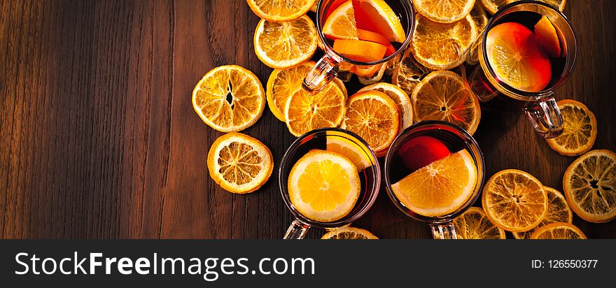 Glintwine with citrus and cranberry. Christmas and winter warming beverage on wooden background
