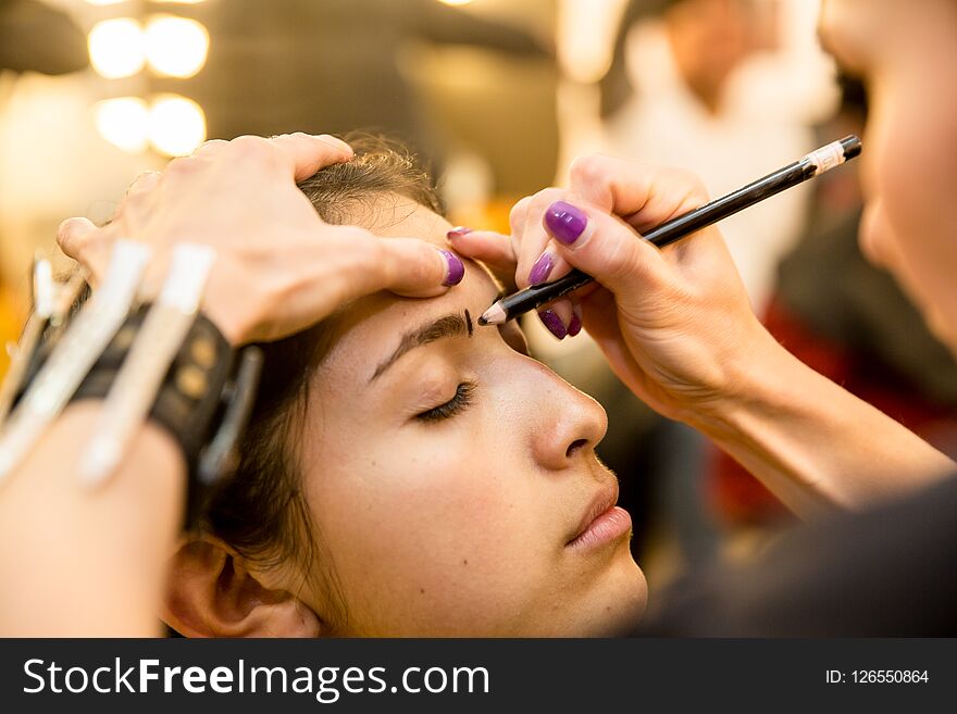 The girl applied makeup in the theater. The girl applied makeup in the theater