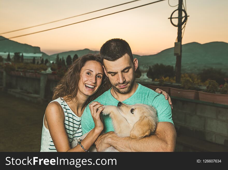 Portrait of a couple with their adorable puppy dog