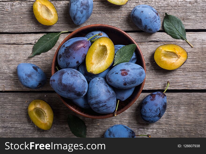 Fresh Plums In Bowl On Wooden Table