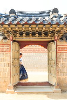 Beautiful Korean Woman Dressed Hanbok Passing The Traditional Door In Palace. Stock Image