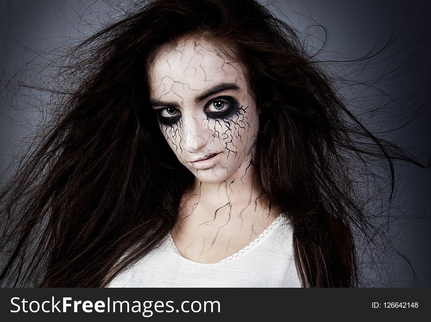 Portrait of a crazy girl with disheveled hair, black eyes and veins. concept of halloween and day of the dead.