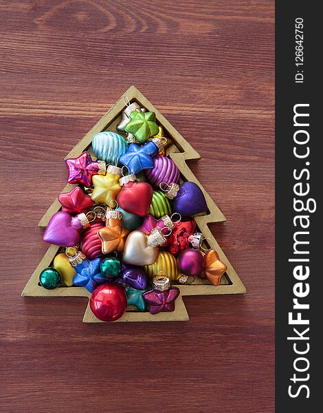 Little christmas tree with colorful baubles on wooden background. Little christmas tree with colorful baubles on wooden background