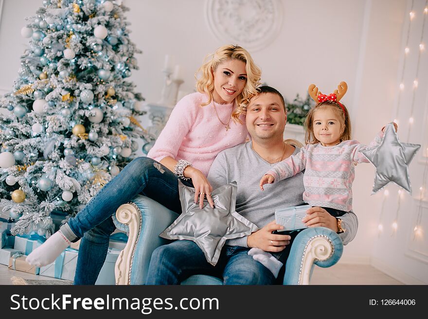 Portrait of young happy family near Christmas tree. Portrait of young happy family near Christmas tree