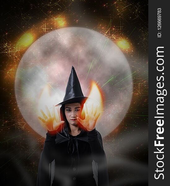 Portrait of woman in black Scary witch halloween costume, magic lights and big moon with Halloween art design background. Portrait of woman in black Scary witch halloween costume, magic lights and big moon with Halloween art design background