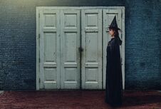 Woman In Black Scary Witch Halloween Costume With Old Brick Wall Stock Images