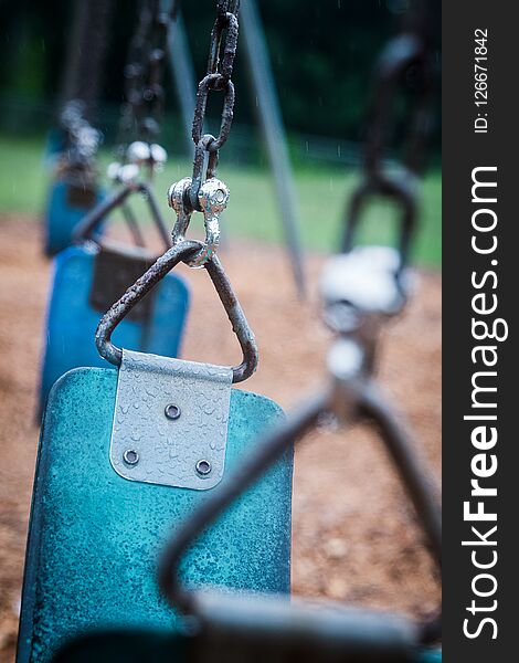 Empty playground during heavy rain downpour. Swings are left alone as no children will come out to play in the wet weather. Empty playground during heavy rain downpour. Swings are left alone as no children will come out to play in the wet weather