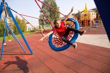 Happy Smiling Girl Swinging On A Swing With Closed Eyes And Arms Outstretched At Playground Royalty Free Stock Photo
